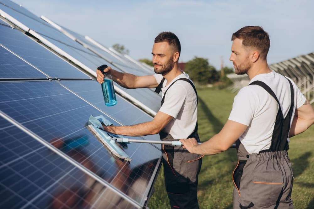 professionnels qui nettoient un panneau solaire